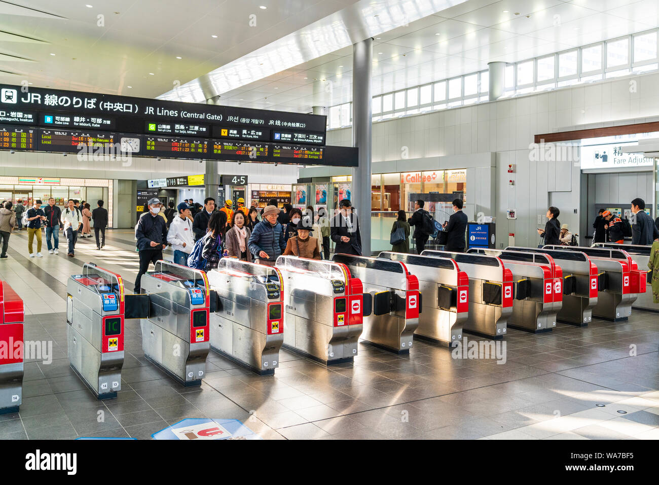 Japan, Hiroshima Station. Zentrale Tor zu JR-Linien und Plattformen mit Ticket Barrieren. Menschen Position heraus durch die Barrieren. Stockfoto