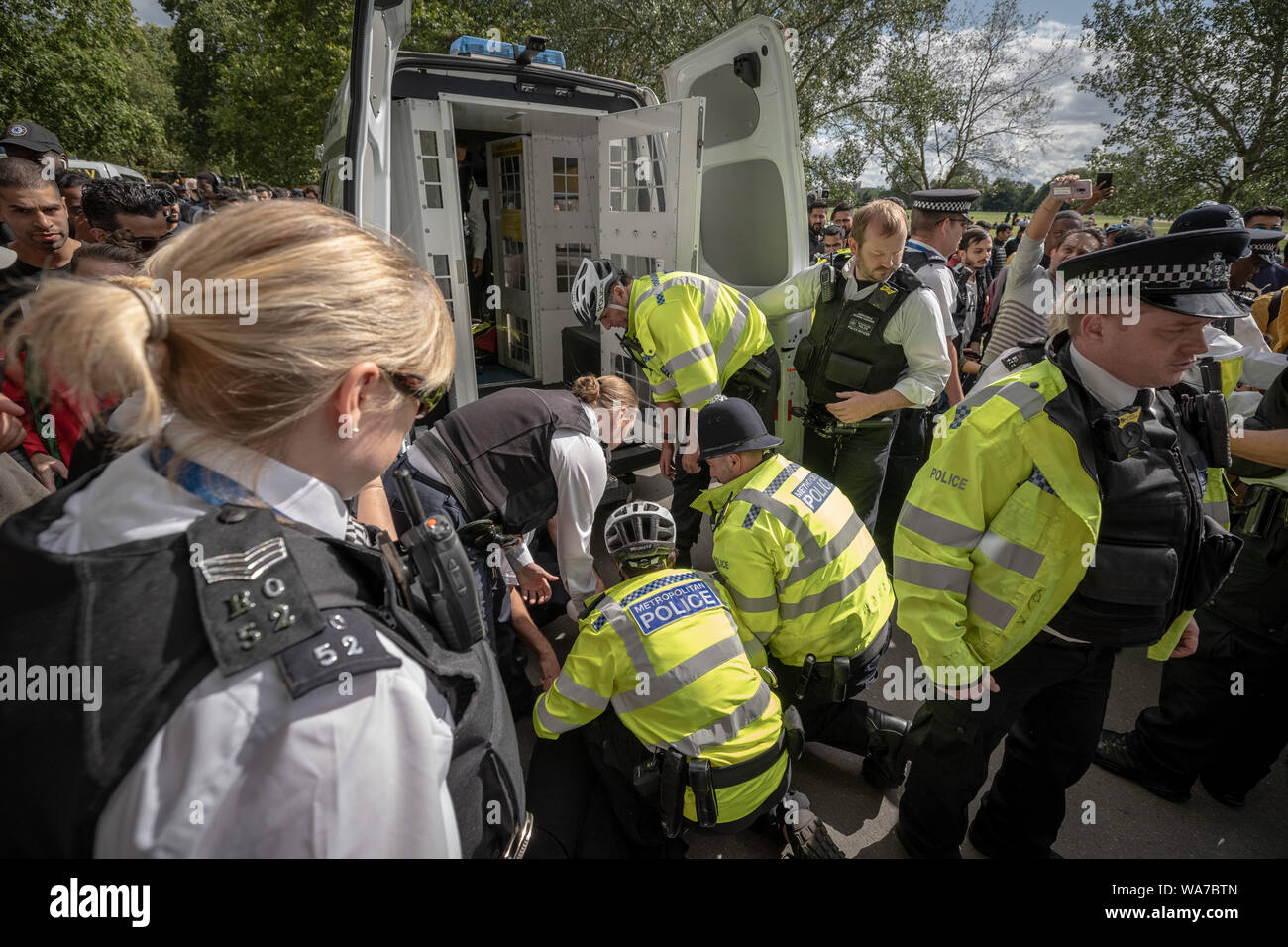 London, Großbritannien. 18 August, 2019. Polizei nimmt eine Frau an Speakers' Corner im Hyde Park, nachdem sie aggressiv angegriffen wurde und ein Polizist, der Ersuchten sie die Park wegen der vorherigen wütend Streitigkeiten und körperliche Auseinandersetzungen verlassen. Credit: Guy Corbishley/Alamy leben Nachrichten Stockfoto