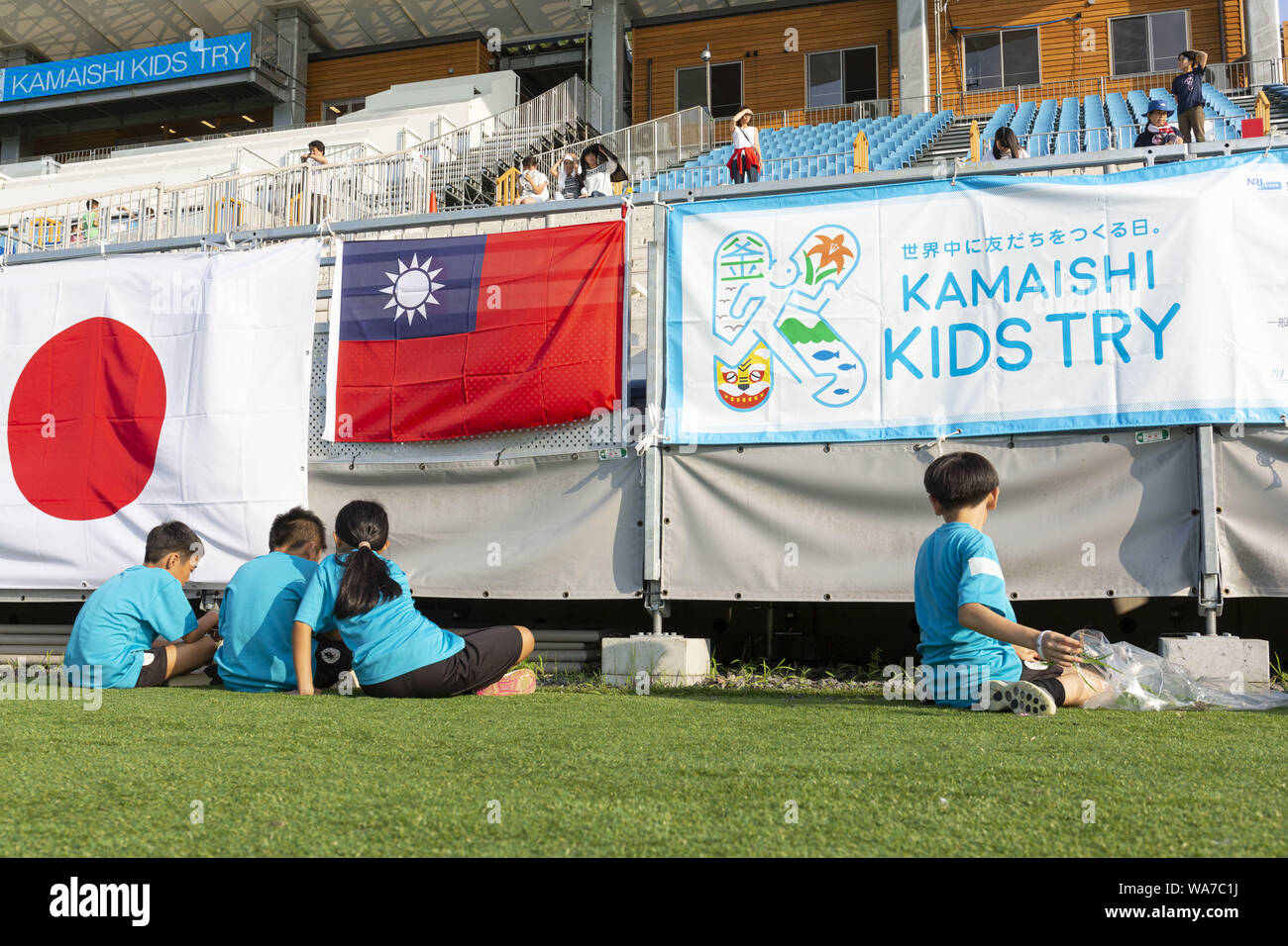 Kamaishi, Japan. 18. August 2019. Grundschule Kinder aus Taiwan, Australien und Japan zeigen ihren Respekt Reinigung das Feld fo Der Kamaishi Unosumai Memorial Stadium nach endete die ''Kamaishi Kinder versuchen'' Sport. Die ''Tohoku Media Tour: Iwate Kurs'' wird von der Tokyo Metropolitan Government in Zusammenarbeit mit den örtlichen Behörden organisiert die Wiederherstellungsmaßnahmen in Tohoku, der von der 2011 grossen Osten Japan Erdbeben und Tsunami Betroffenen zu präsentieren. Der Kamaishi Unosumai Memorial Stadium oder Kamaishi Recovery Memorial Stadium bewirten die Fidschi V Uruguay und Namibia V Kanada stimmen mit Stockfoto