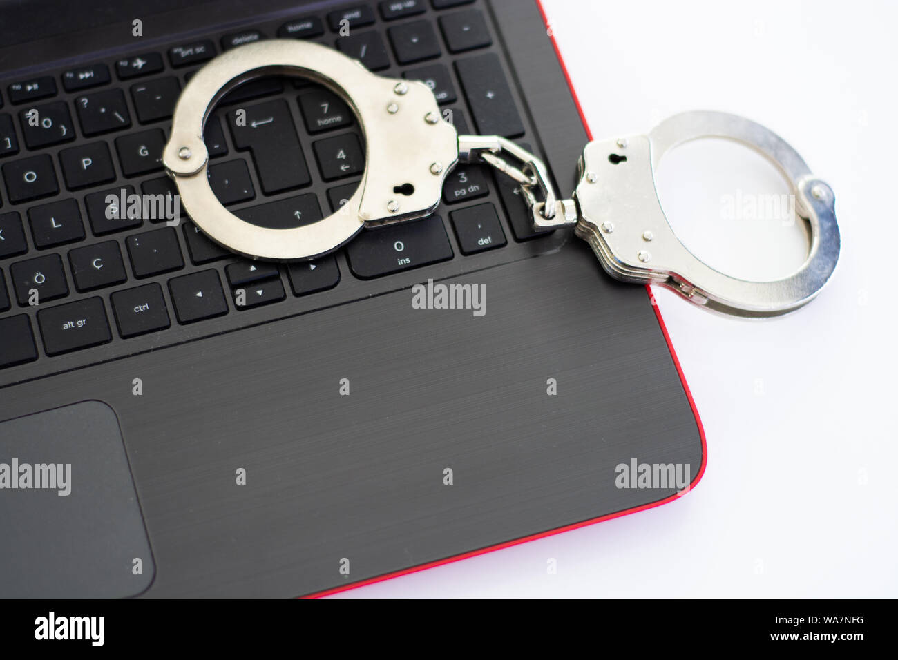Internetkriminalität Konzept. Handschellen auf Laptop Stockfoto