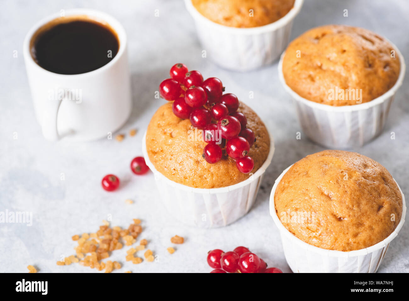 Hausgemachte süsse Vanille Muffins mit roten Beeren und Tasse schwarzen Kaffee Espresso eingerichtet Stockfoto