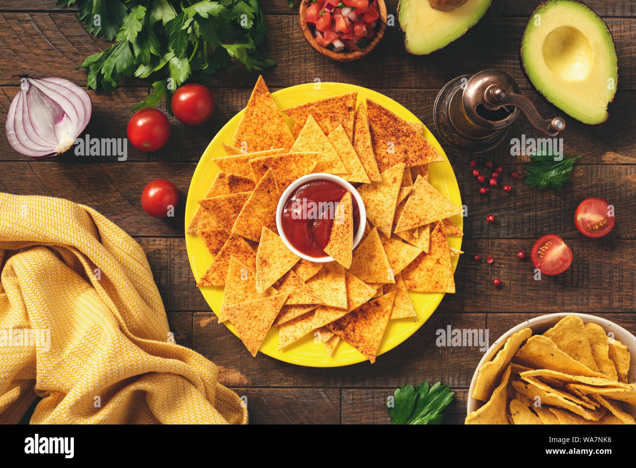 Mais Tortilla Chips, Nachos mit Tomatensauce an der Platte. Tex Mex Vorspeise oder Snack auf Holz- Hintergrund. Ansicht von oben Stockfoto