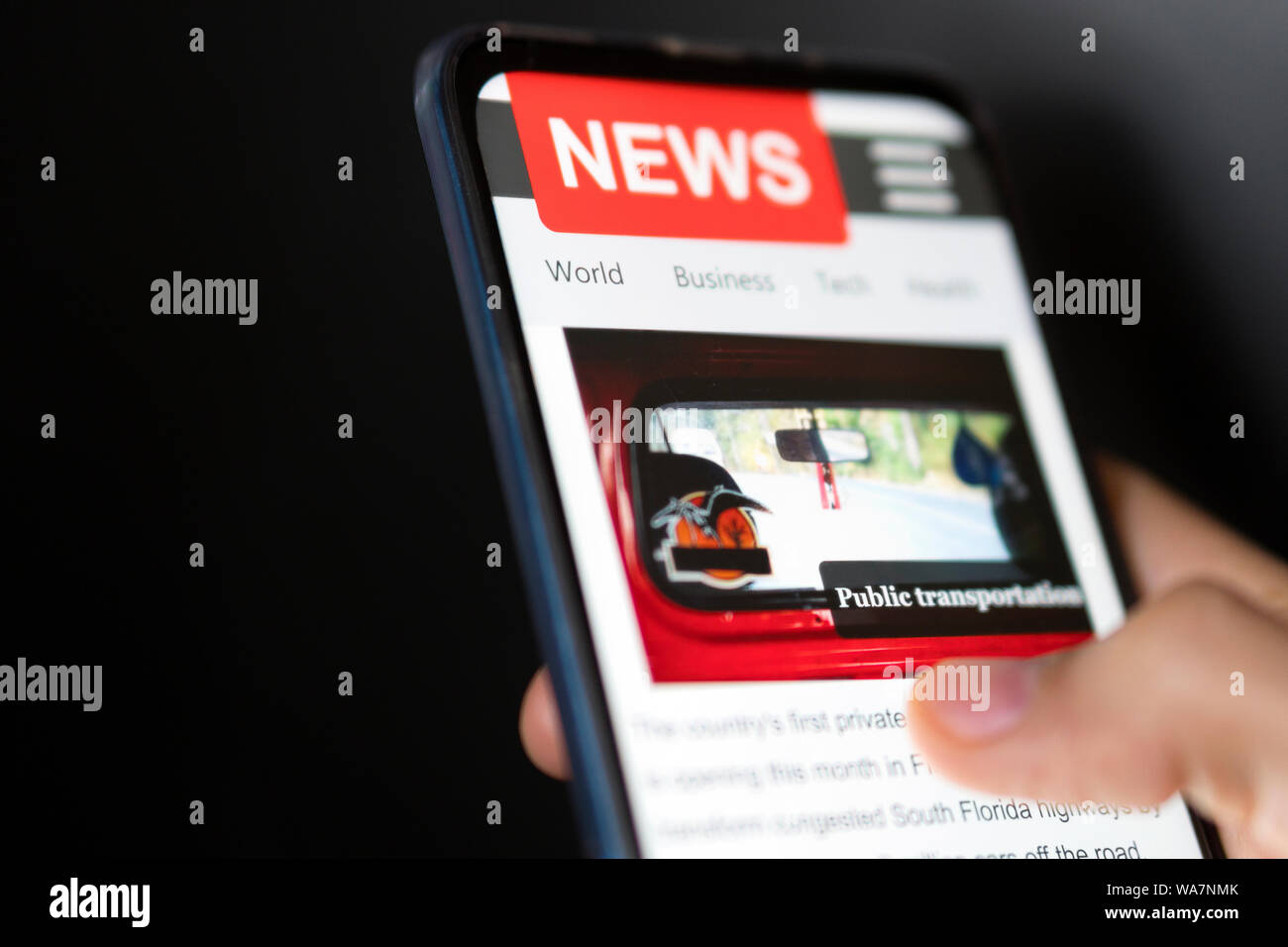 Ein Mann hält smart phone mit Nachrichten auf dem Bildschirm. Zeitung online Portal im Browser. Stockfoto