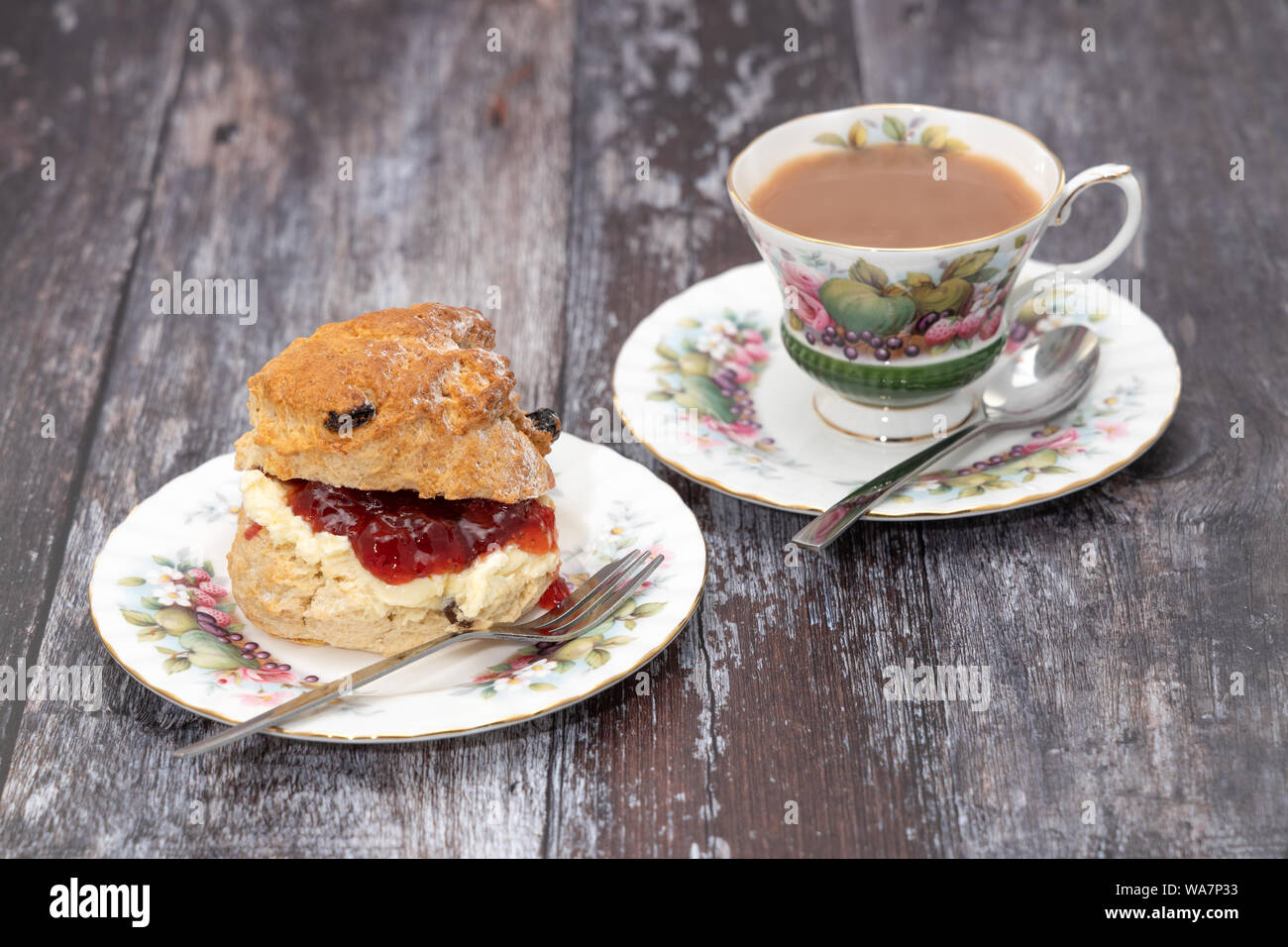 Scone mit Sahne und Marmelade mit einer Tasse Kaffee serviert. Stockfoto