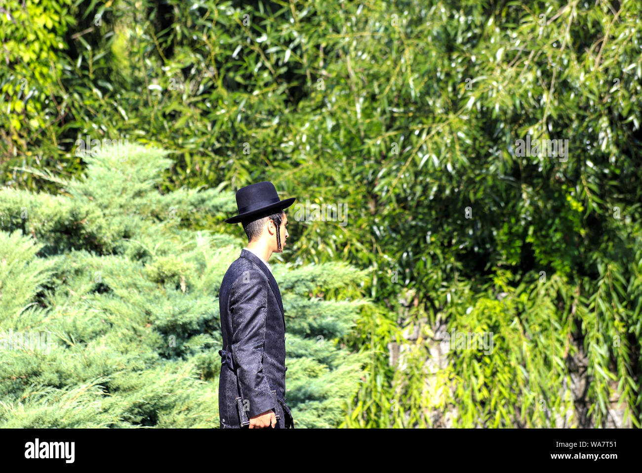 Uman, Ukraine 11.09 2018. Ein junger Jude Hasid Junge in traditionelle schwarze Kleidung steht in Uman Park, der das Jüdische Neue Jahr, frommen Juden Stockfoto