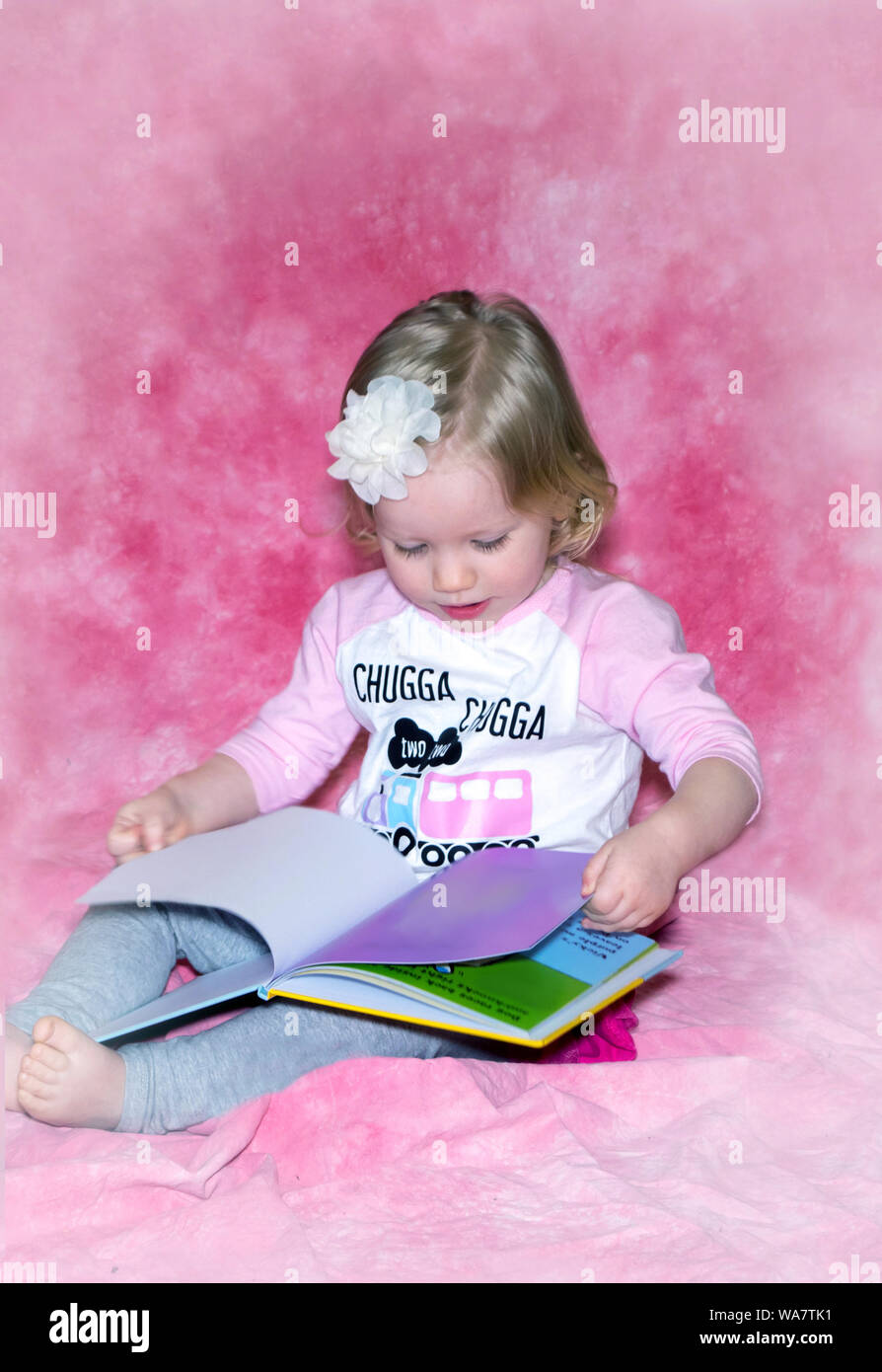 Kleinkind schaut durch ein Bilderbuch Stockfoto