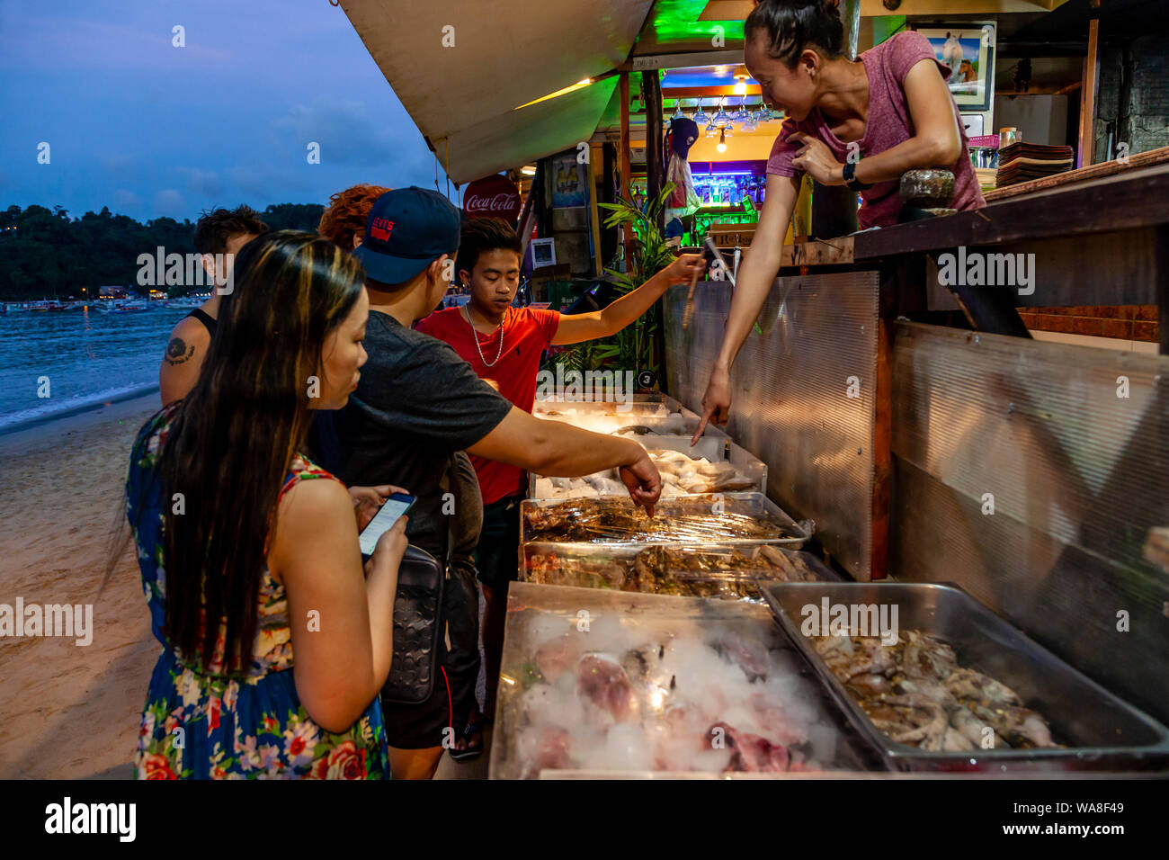 Touristen die Wahl Fisch aus dem frische Meeresfrüchte Anzeige außerhalb ein Restaurant am Strand, El Nido, Palawan, Philippinen Stockfoto