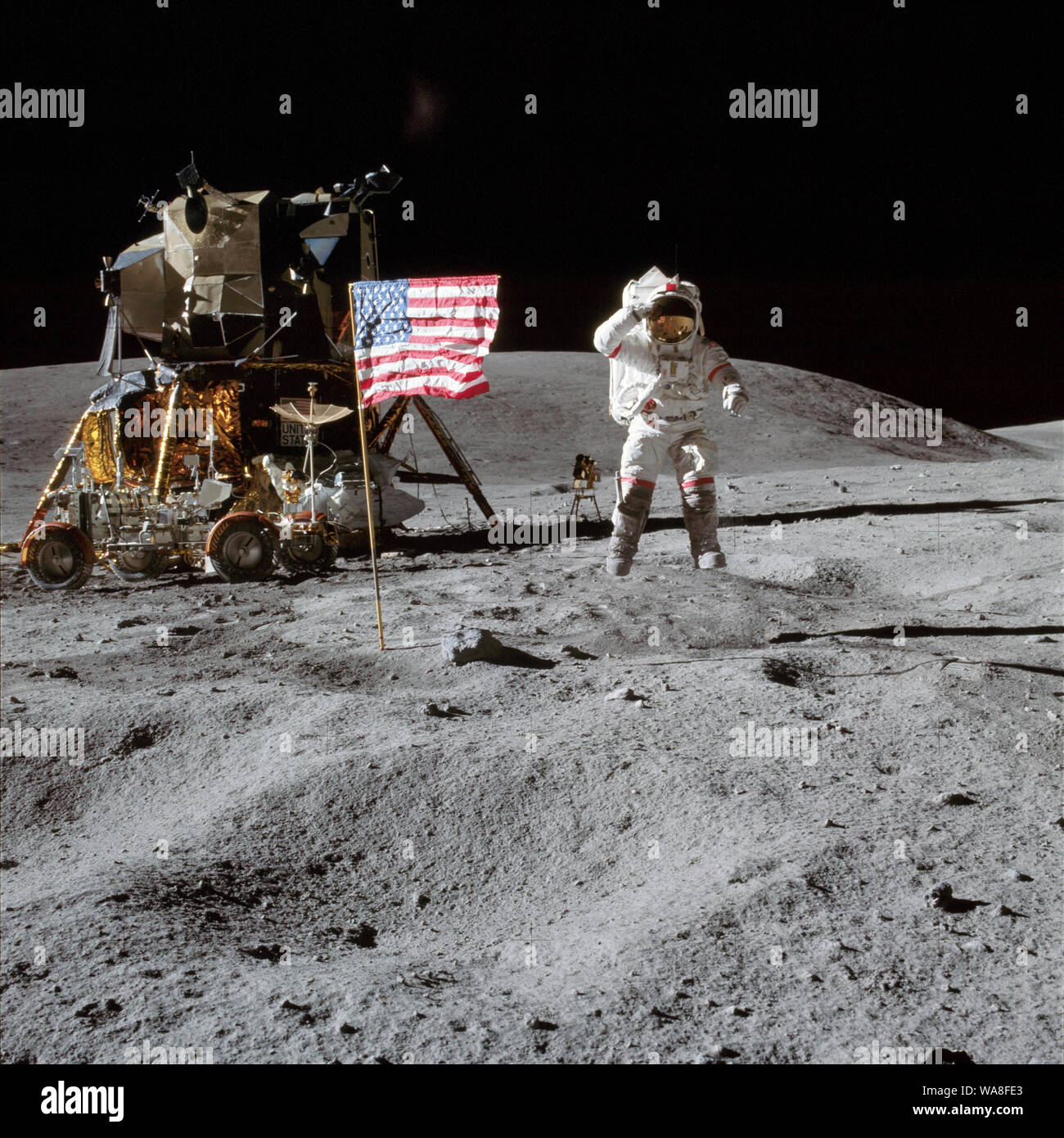 Junge springt, während Salutierte die amerikanische Flagge während der Apollo 16 - John W. Junge auf dem Mond während der Apollo 16 Mission. Charles M.Herzog Jr. nahm dieses Bild. Das LM Orion befindet sich auf der linken Seite. 21. April 1972 Stockfoto