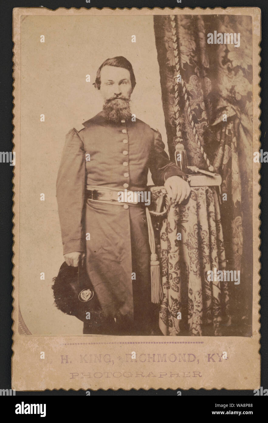 Captain John Wilson von Co.C, 8 Kentucky Infanterie Regiment (Union), in Uniform mit Schwert, Revolver und buchen Sie sich auf Tisch]/H.König, Richmond, Ky., Fotograf Stockfoto