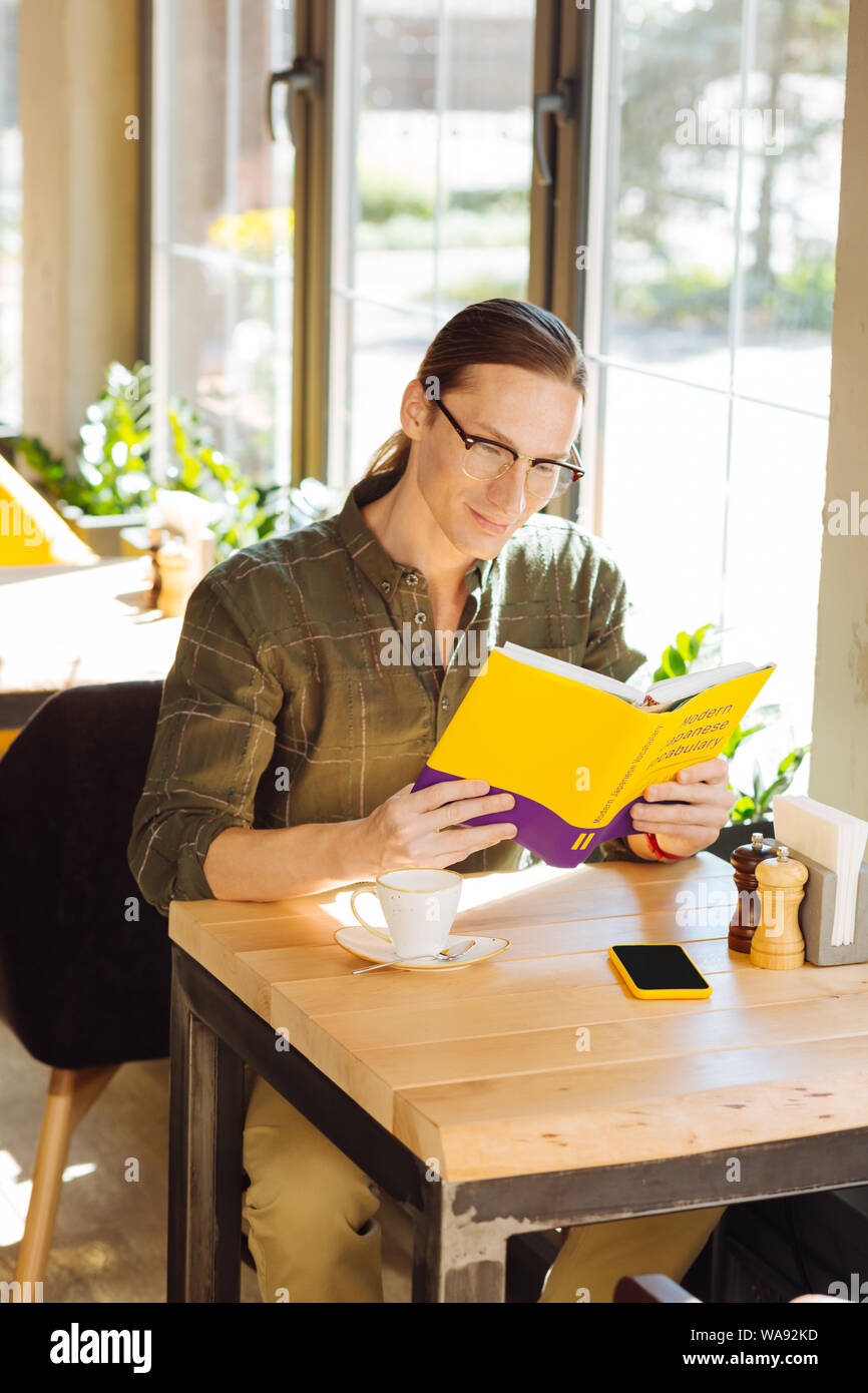 Freudige intelligenter Mann, Japanisch zu lernen, Stockfoto