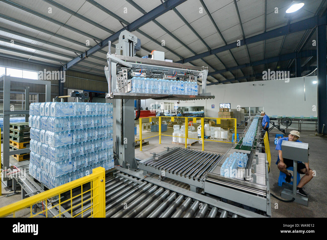 Chinesische Arbeiter produzieren Flaschen Mineralwasser auf einem Fließband in einer Anlage in Changxing Grafschaft, Stadt Huzhou, der ostchinesischen Provinz Zhejiang, 28 J Stockfoto