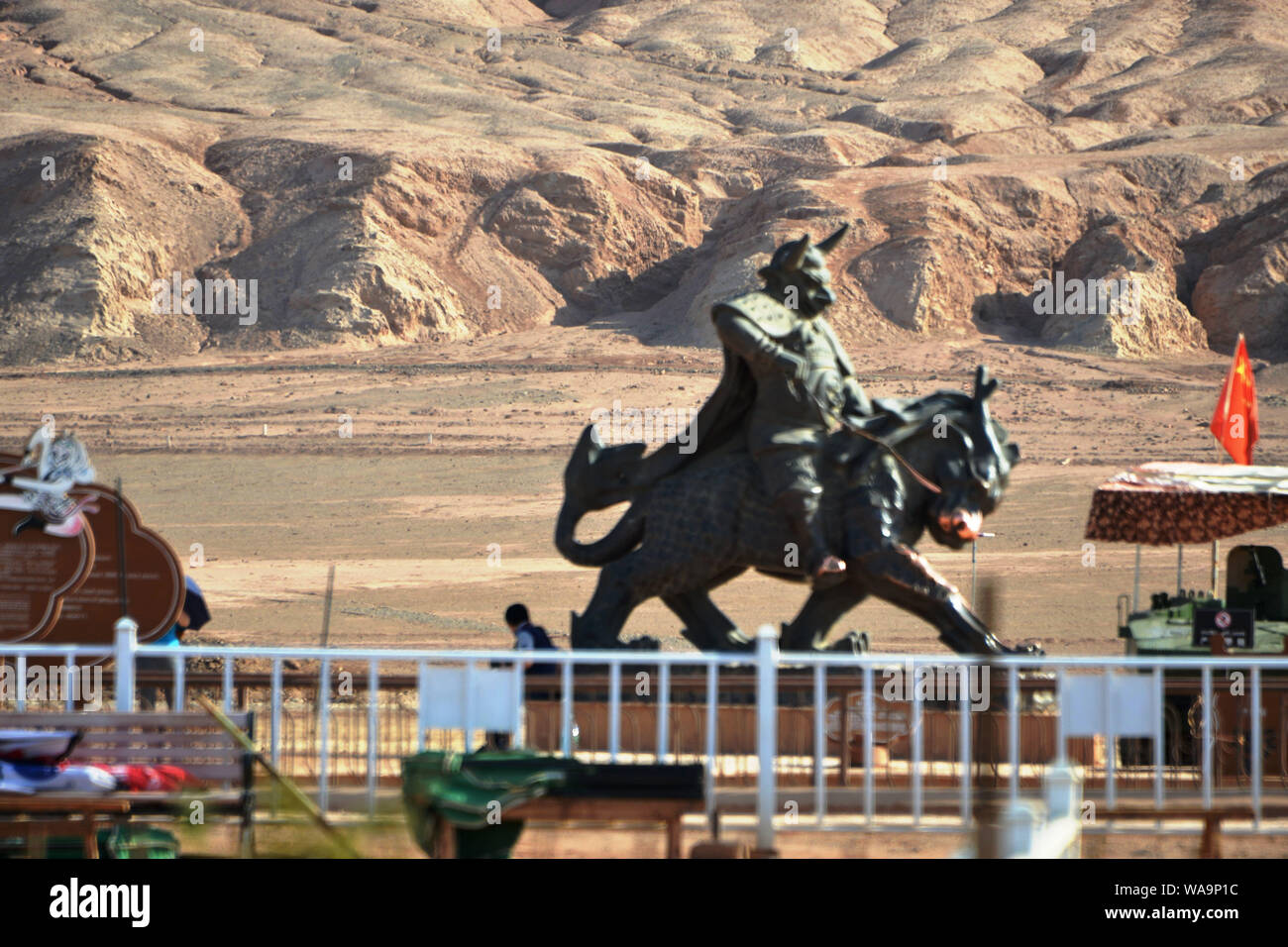 Touristen posieren für Fotos mit den Sehenswürdigkeiten Skulptur am Fuße des Huoyan (Flaming) Berg in Turpan Becken, im Nordwesten Chinas Xinjiang Uygur au Stockfoto