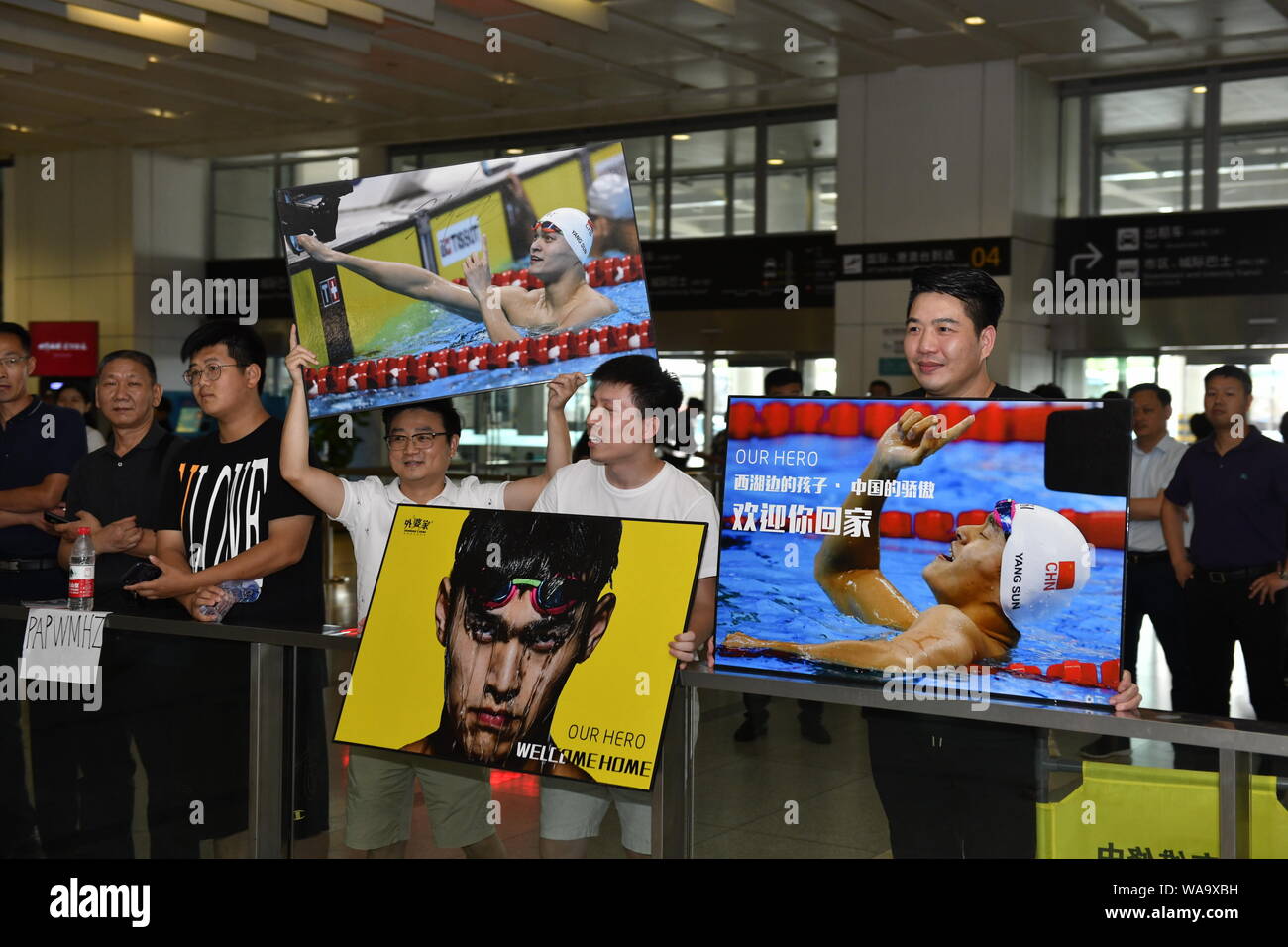 Chinesische Fans halten Bilder der Chinesischen schwimmen Olympiasieger Sun Yang, wie Sie an der Hangzhou Xiaoshan International Airport in Hangzhou city warten. Stockfoto