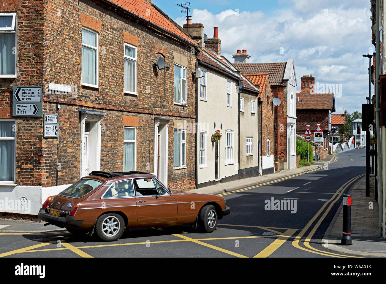 MGB GT-Sportwagen an der Kreuzung im Dorf Cawood, North Yorkshire, England, Großbritannien Stockfoto