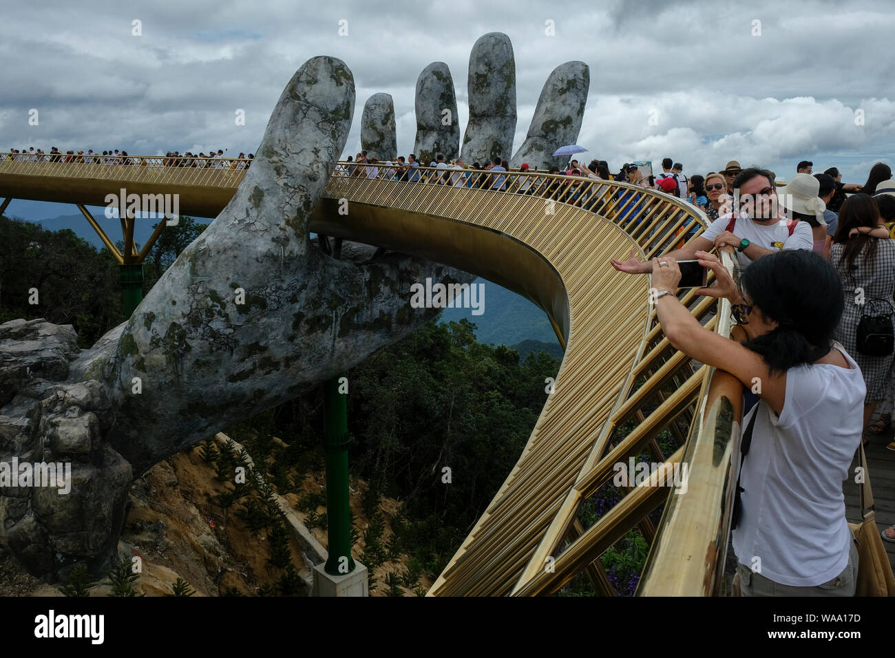 Da Nang, Vietnam - am 18. August 2018: Touristen in der Golden Bridge. Die Goldene Brücke ist eine 150 m lange Fußgängerbrücke in der Ba Na Hügeln in Da Nang. Stockfoto