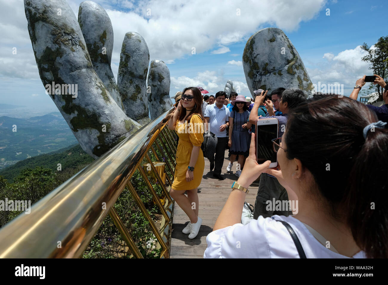 Da Nang, Vietnam - am 18. August 2018: Touristen in der Golden Bridge. Die Goldene Brücke ist eine 150 m lange Fußgängerbrücke in der Ba Na Hügeln in Da Nang. Stockfoto