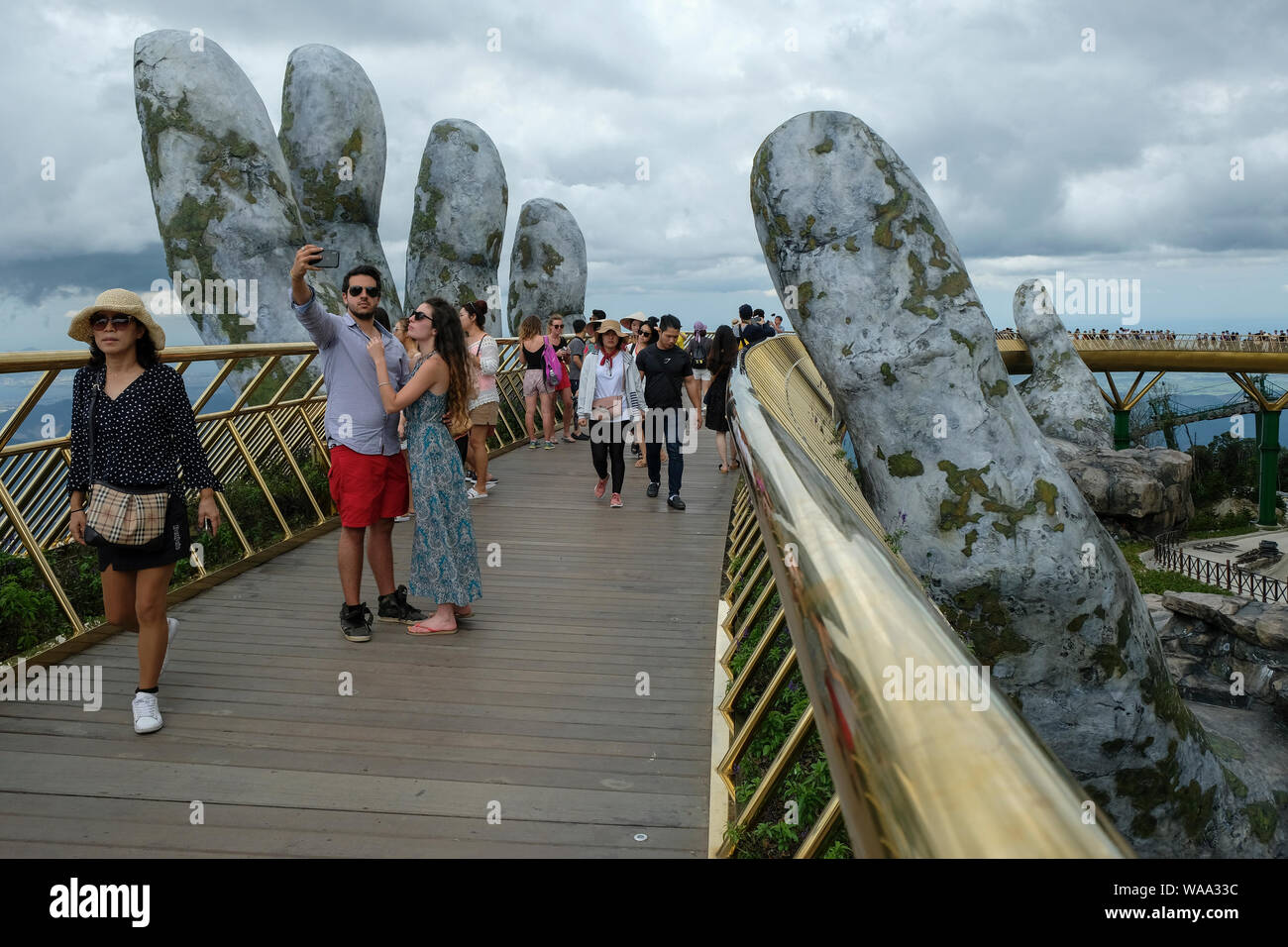 Da Nang, Vietnam - am 18. August 2018: Touristen in der Golden Bridge. Die Goldene Brücke ist eine 150 m lange Fußgängerbrücke in der Ba Na Hügeln in Da Nang. Stockfoto