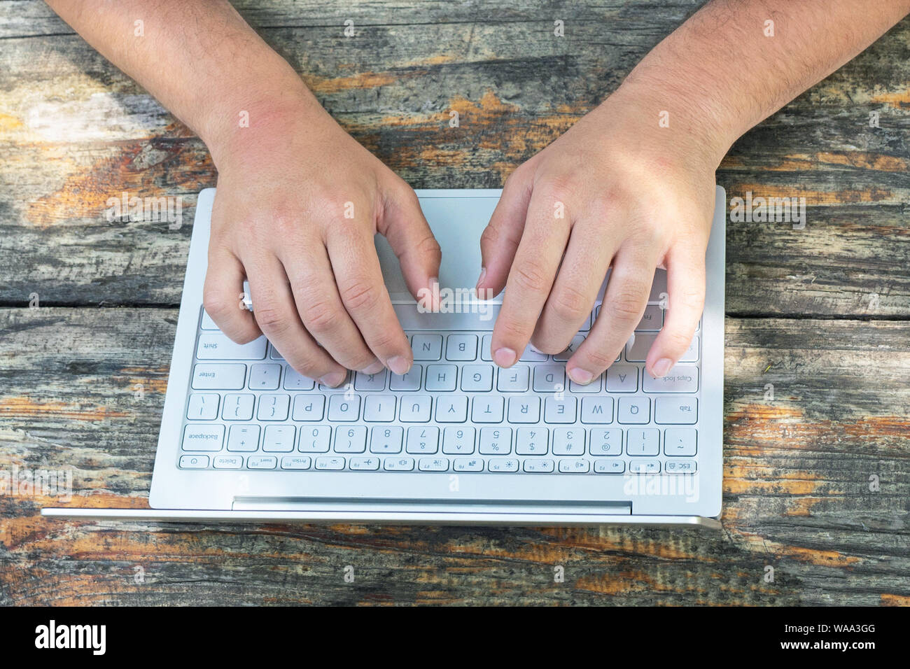 Business, Bildung, Menschen und Technologie. Nahaufnahme der Männer Hände mit Laptop Tastatur auf hölzernen Tisch Hintergrund. Ansicht von oben. Stockfoto