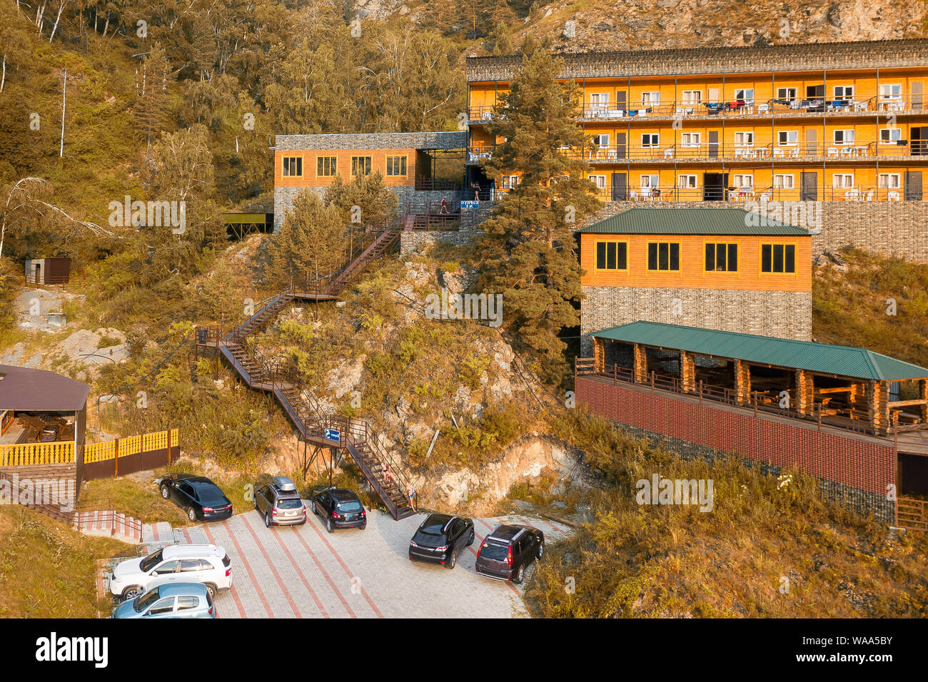 Luftaufnahme von Holzhäuser und Hotels im Altai Gebirge zwischen den Felsen und gelbe Bäume für Entspannung und Unterkunft während touristische Ausflüge Stockfoto