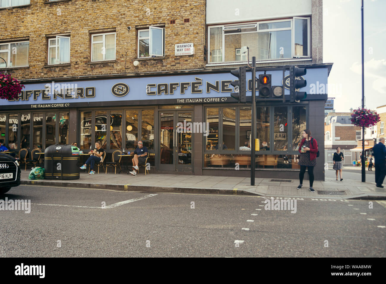 London, UK/16 Juli 2019: Menschen sitzen an den Tischen vor dem Caffe Nero auf den Warwick Way in Pimlico, London, Großbritannien; selektive Fokus Stockfoto