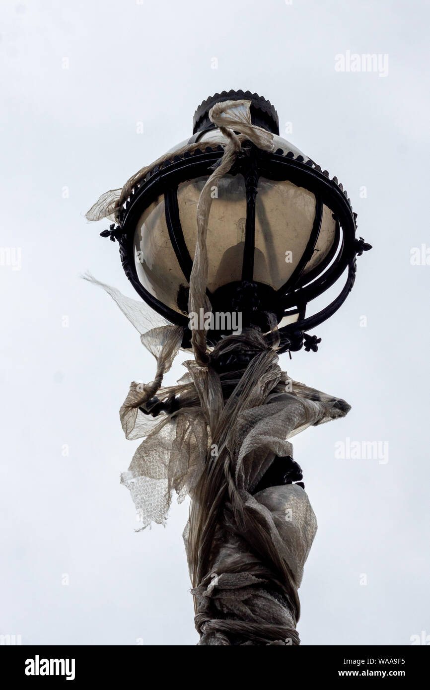 Alte Lamppost an der Themse in London in Plastik gewickelt, im Wind wehend - moderne Verpackung? Stockfoto