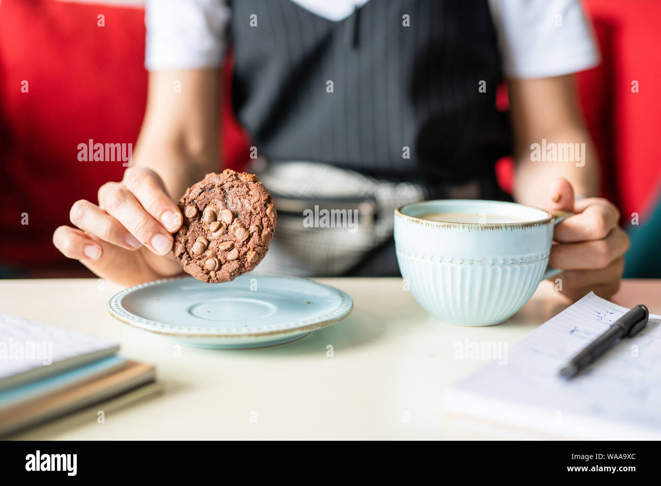 Geschäftsfrau holding Runde Schokolade Cookie mit Muttern über Platte Stockfoto