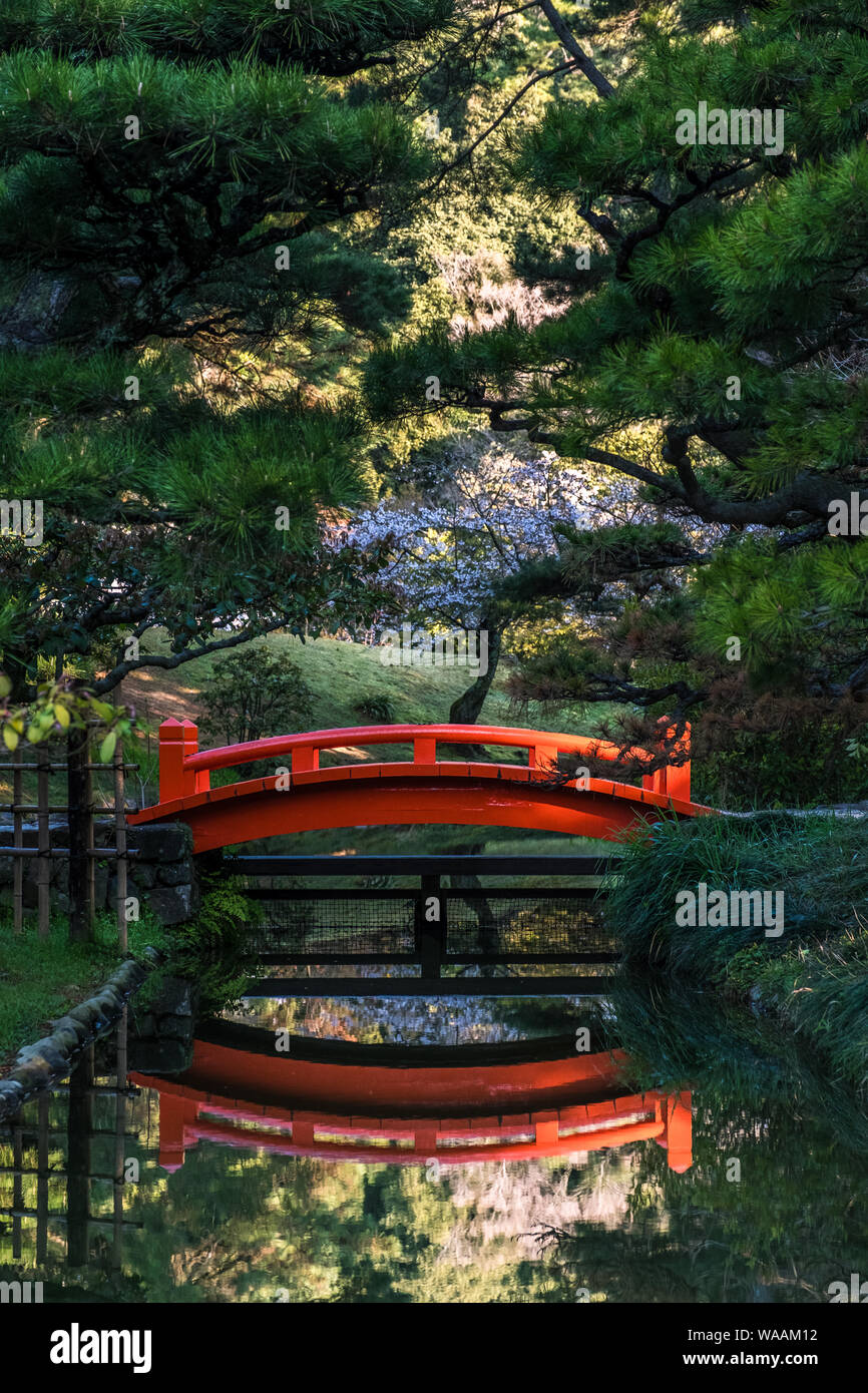 Eine leuchtende rote Brücke und ihre Reflexion im Ritsurin Garden in Shikoku, Japan Stockfoto