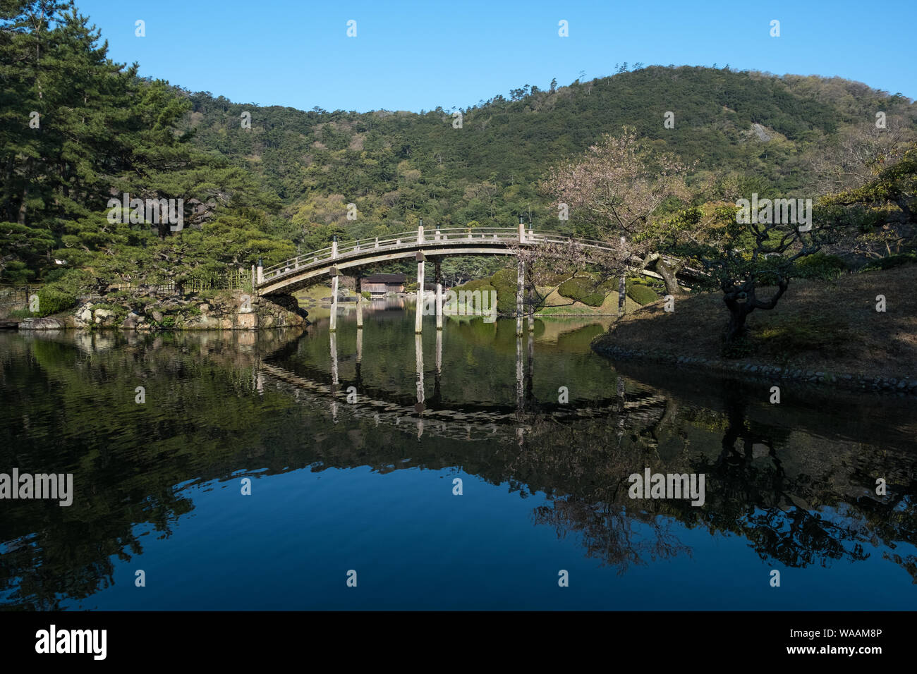 Crescent Mond-Brücke und ein blauer Himmel im Ritsurin Garden in Shikoku, Japan Stockfoto