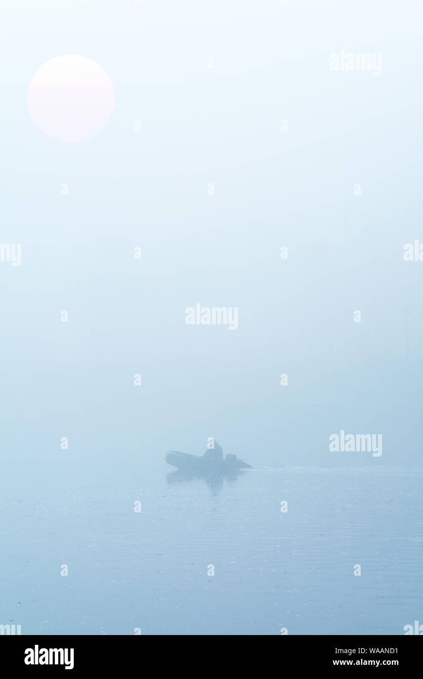 Fischer auf dem Boot im Nebel Stockfoto