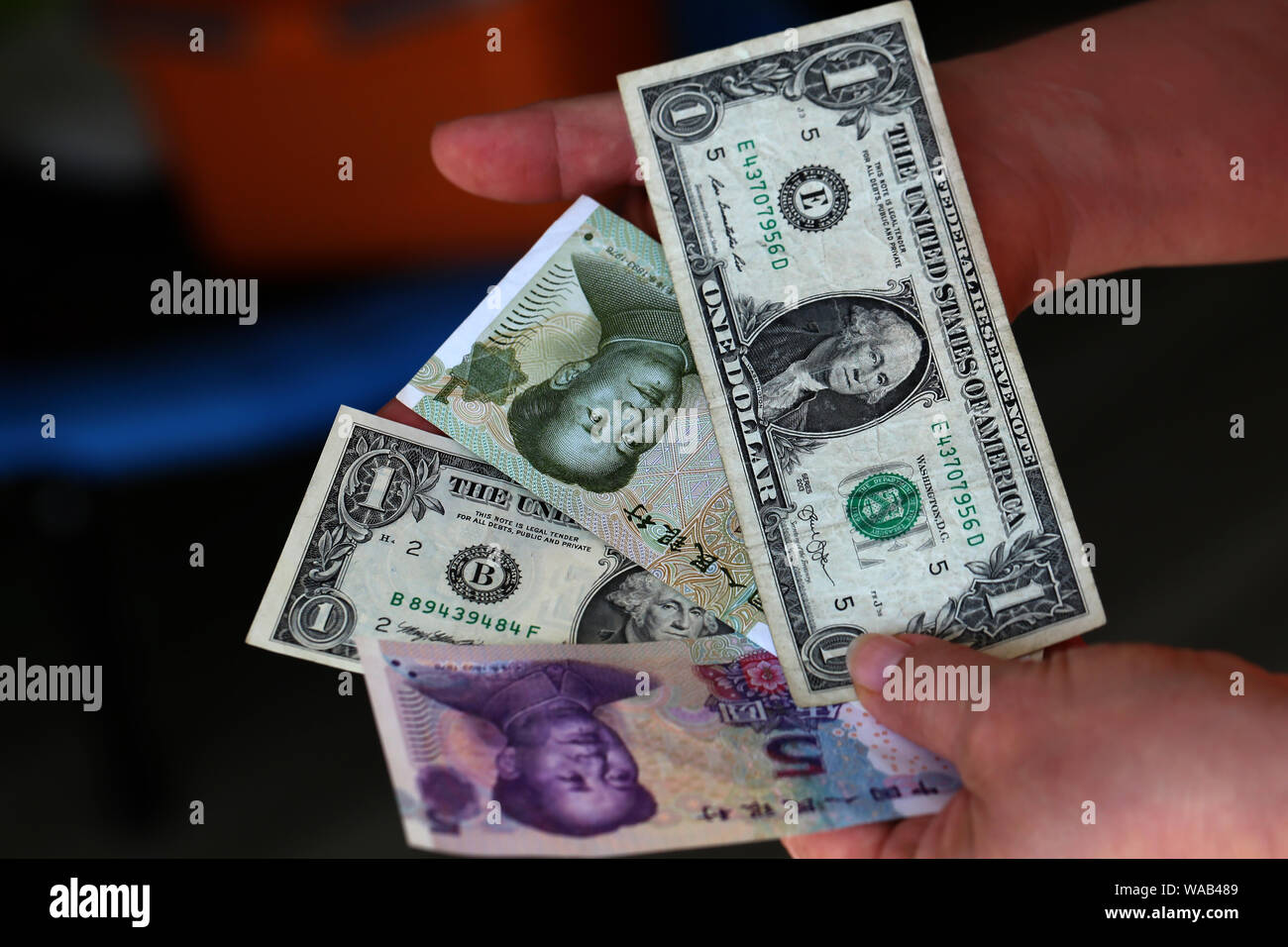 Dollar vs Yuan. Dollar und Yuan in den Händen Stockfoto