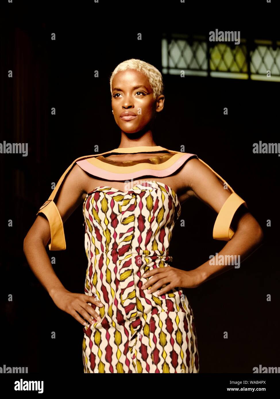 Ein gebleichtes, blondes schwarzes Model geht für Designer Muhire während der London Africa Fashion Week. Stockfoto