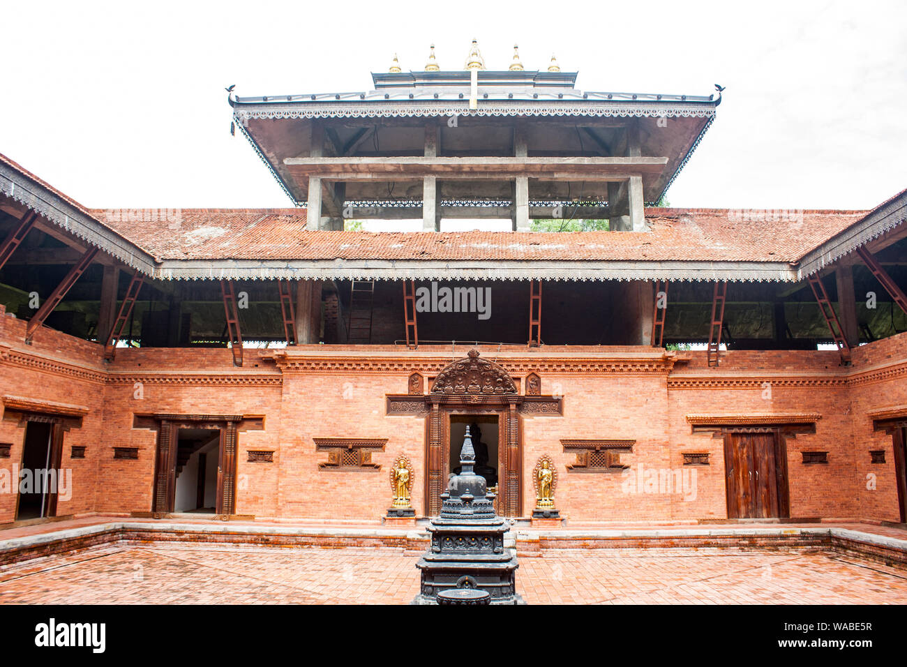 Kloster, Bajrayan nepalesischen Lumbini, Nepal. Nepali Newari cultural Design mit rotem Backstein und Holz gestaltete Tür und Fenster. Stockfoto