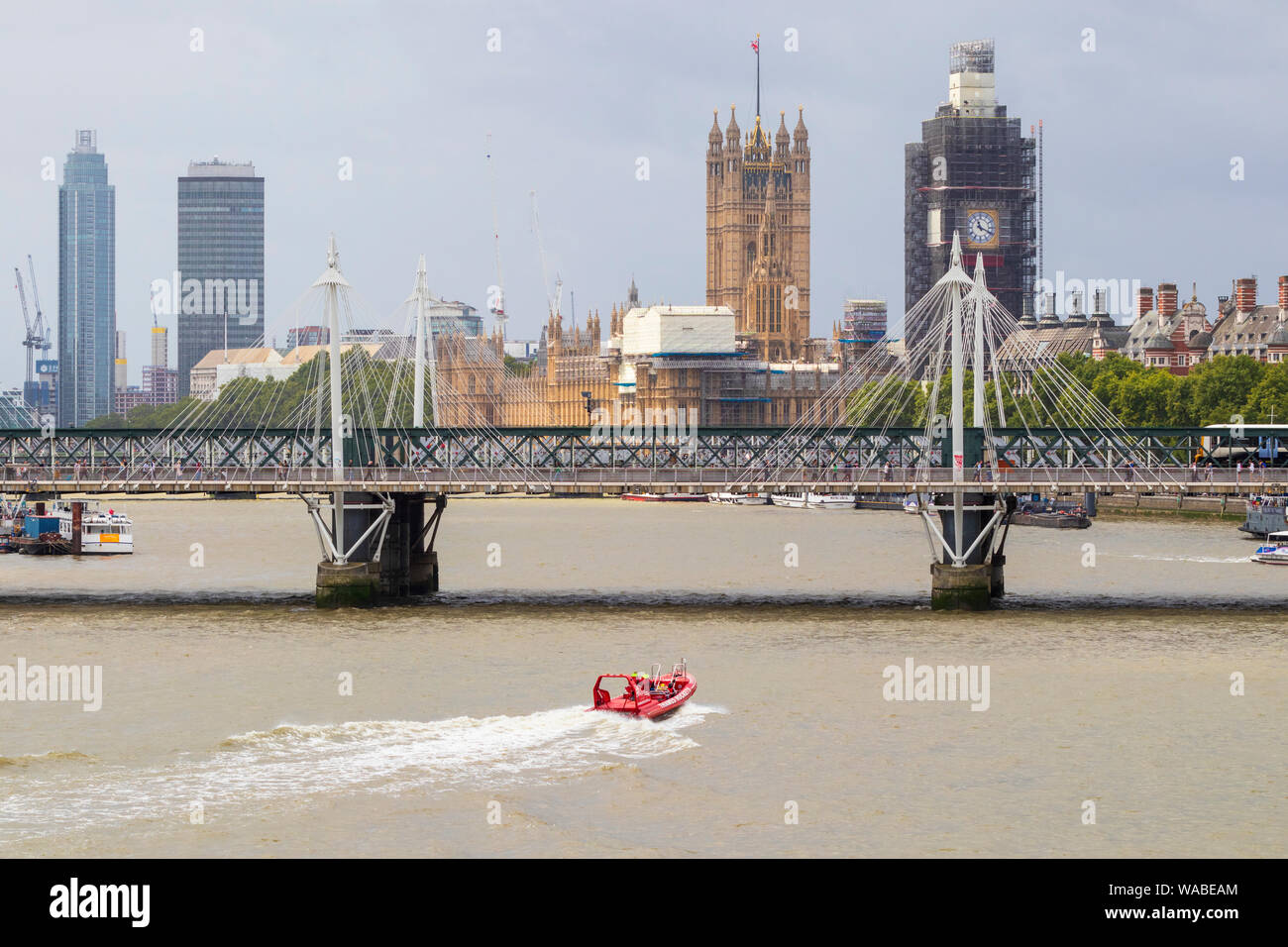 Thames Raketen Motorboot Anfahren der hungerford Eisenbahn- und Golden Jubilee Fuß Brücken auf der Themse, London, UK Stockfoto