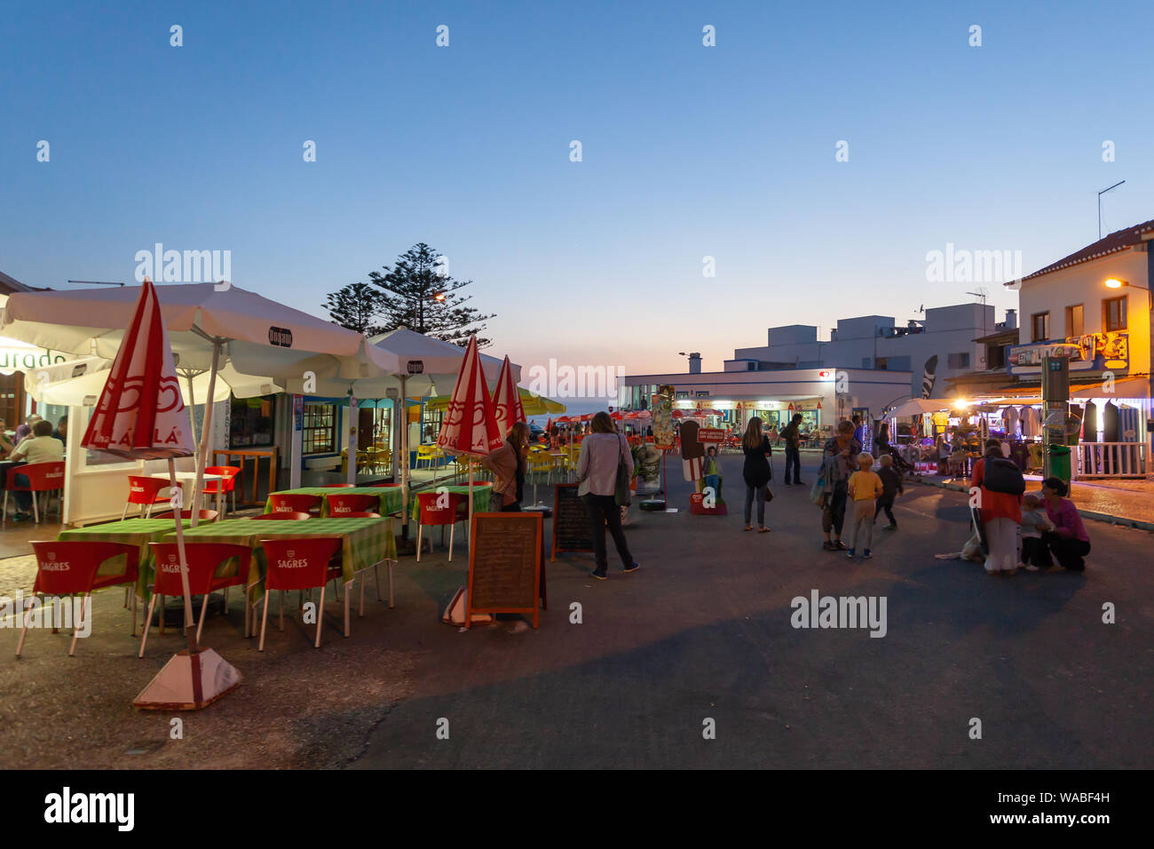 Touristen genießen den warmen Sommerabend in Zambujeira do Mar, einer Küstenstadt an der Atlantikküste in Alentejo, Portugal. Stockfoto