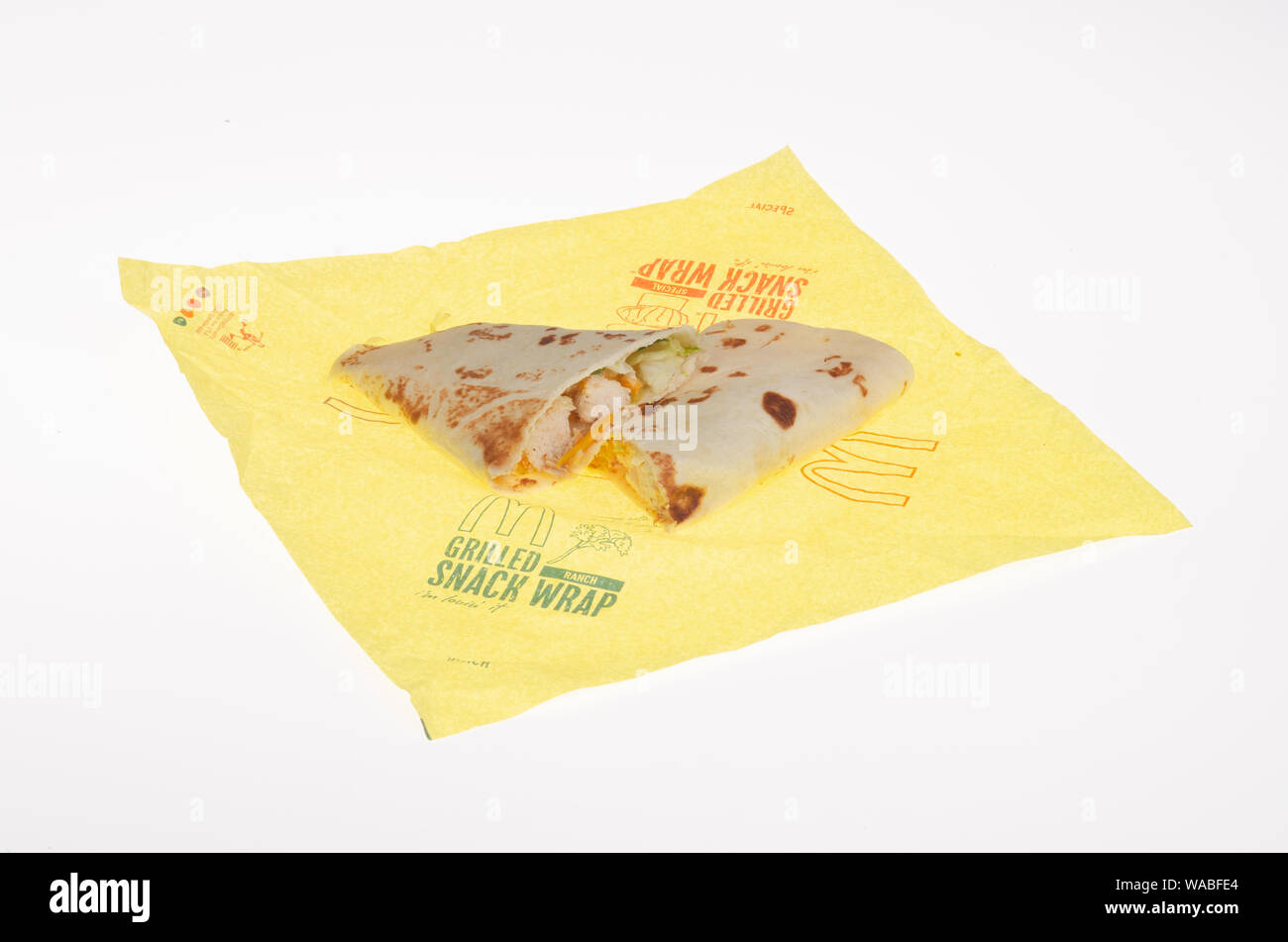 McDonald's Snack vom Grill Ranch Chicken wrap halbiert auf wrapper Huhn angezeigt, geriebenem Käse und Salat auf Mehl tortilla Stockfoto
