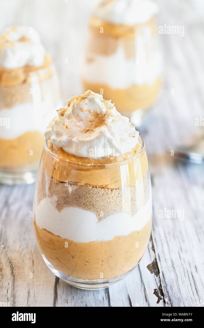 Hausgemachte Kürbis kleinigkeit Dessert von kürbispüree, Frischkäse, cookie Krümel und Schlagsahne. Extreme selektiven Fokus mit unscharfen backgroun Stockfoto