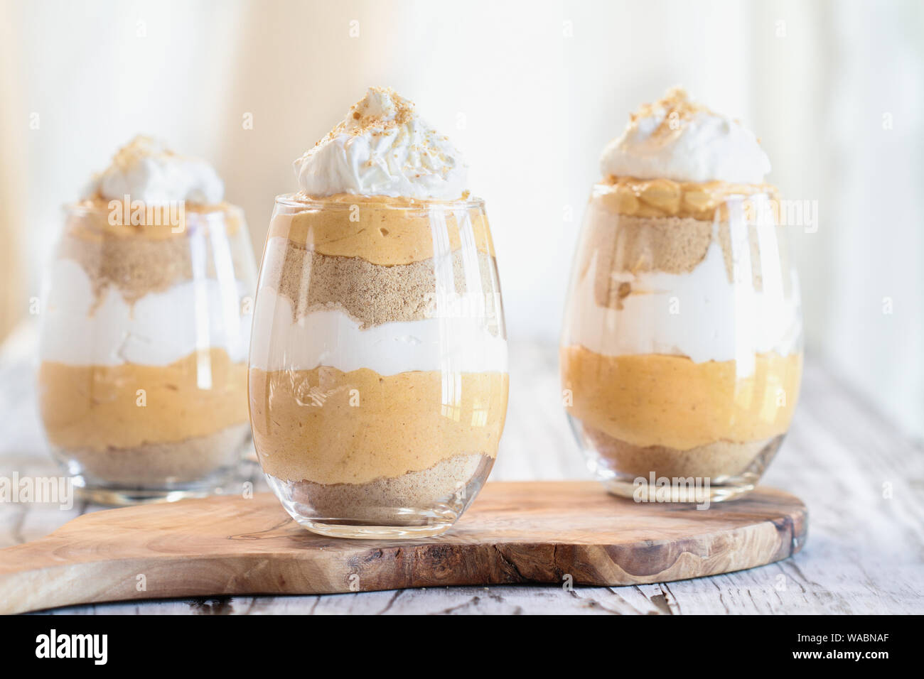 Hausgemachte Kürbis kleinigkeit Dessert von kürbispüree, Frischkäse, cookie Krümel und Schlagsahne. Extreme selektiven Fokus mit unscharfen backgroun Stockfoto