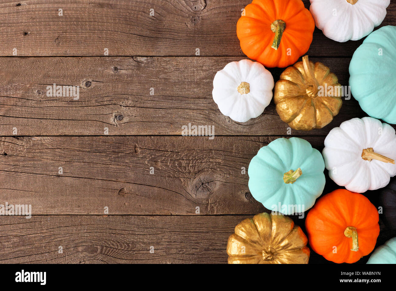 Herbst Seite Grenze von verschiedenen bunten Kürbisse auf einem rustikalen, mit Holz Hintergrund. Ansicht von oben mit der Kopie. Stockfoto