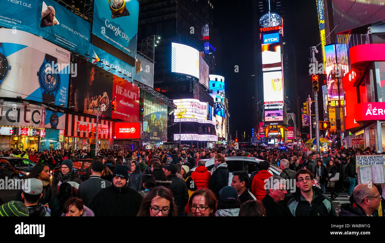 New York City, USA, 28. Dezember 2014, unzählige Menschen das pulsierende Nachtleben im berühmten Times Square Kreuzung bei Nacht genießen Stockfoto