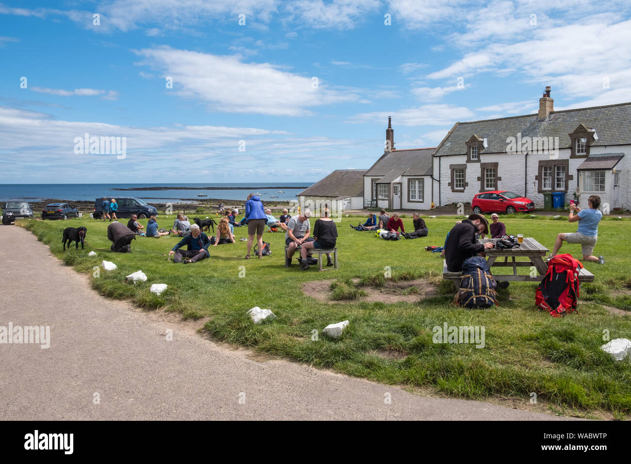 Kunden Essen und Trinken außerhalb des Ship Inn bei niedrigen Newton-by-the-Sea, Alnwick, Northumberland, Großbritannien Stockfoto