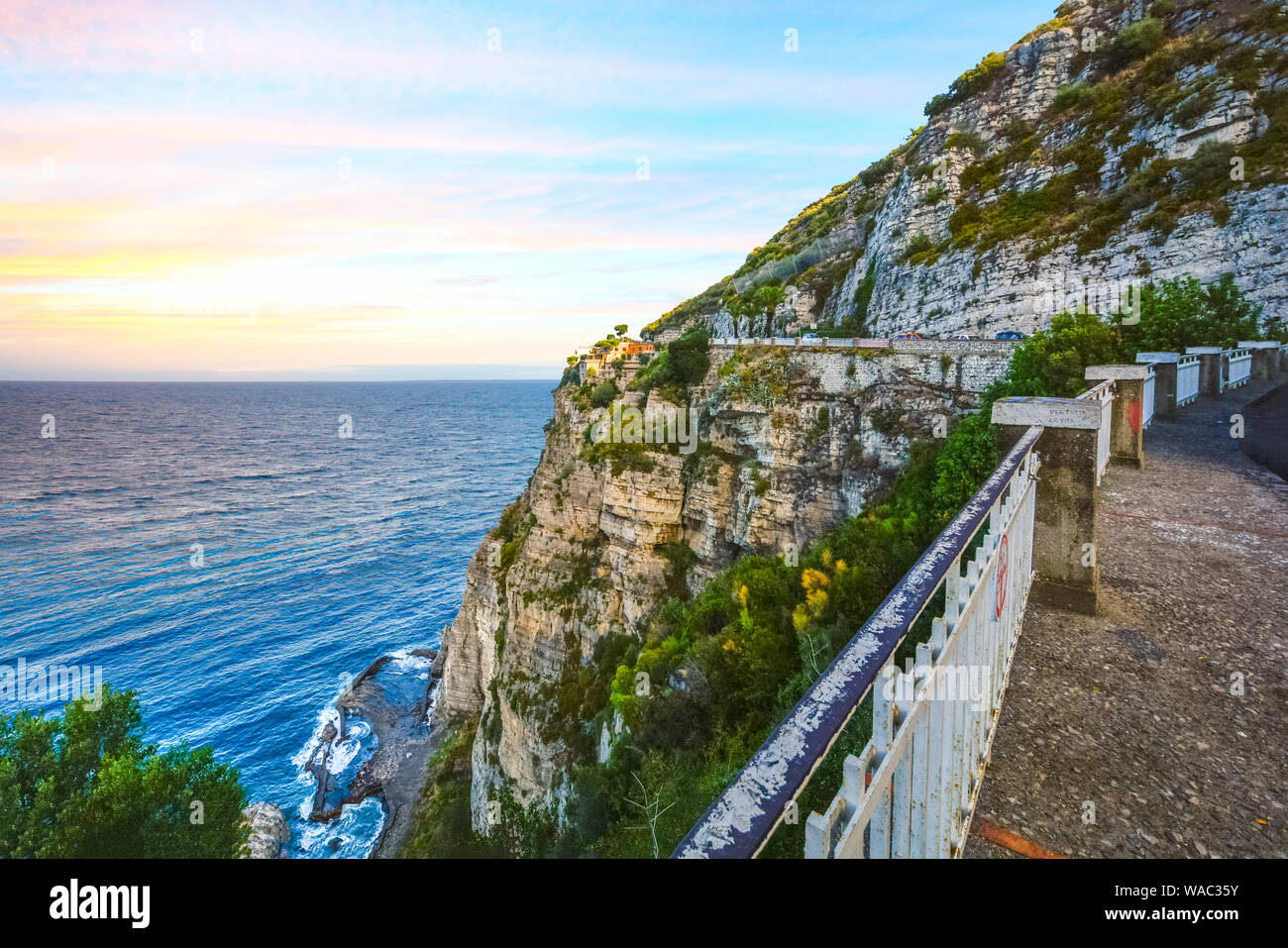 Blick vom Stillstand auf dem Weg an der Amalfi-Küste in der Nähe von Sorrent mit einer Luxus-Villa hoch oben auf einer Klippe mit dem Meer und Tide Pools unten Stockfoto
