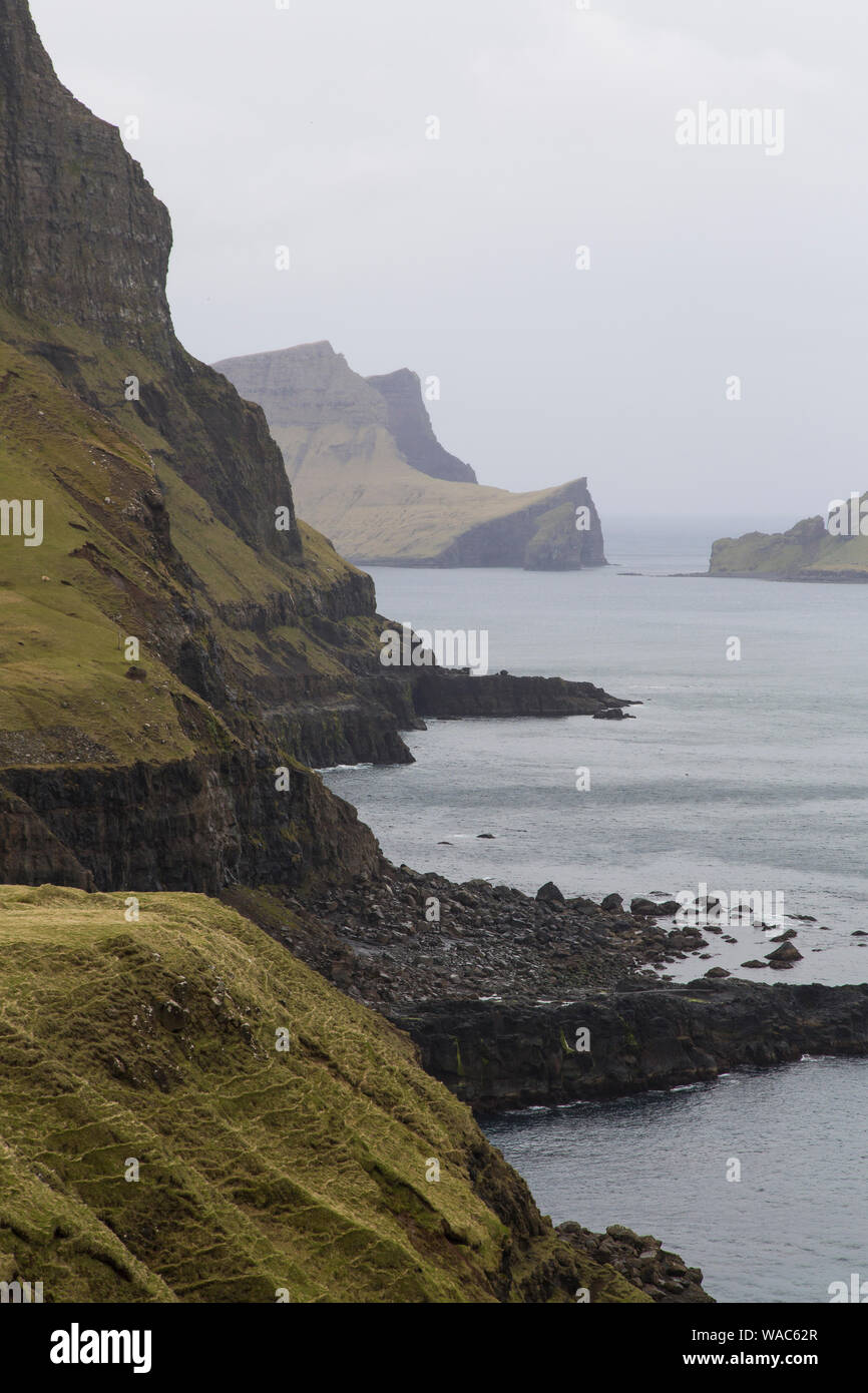 Berghänge in einem nebligen Atmosphäre auf der Insel Vágar, Faeröer, Dänemark Stockfoto