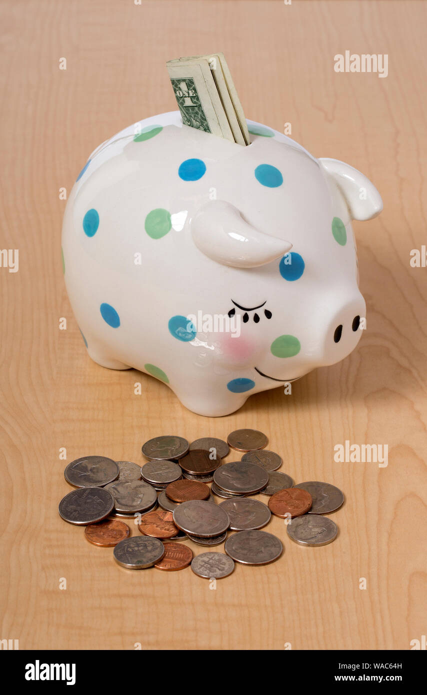 Ein Kind weiß mit Flecken Sparschwein und Geld Stockfoto