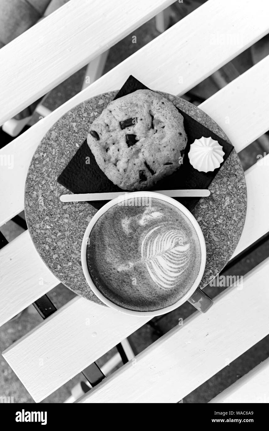 Kaffee in einem türkis Becher und Cookies auf einem weißen Tisch Ansicht Oben Stockfoto