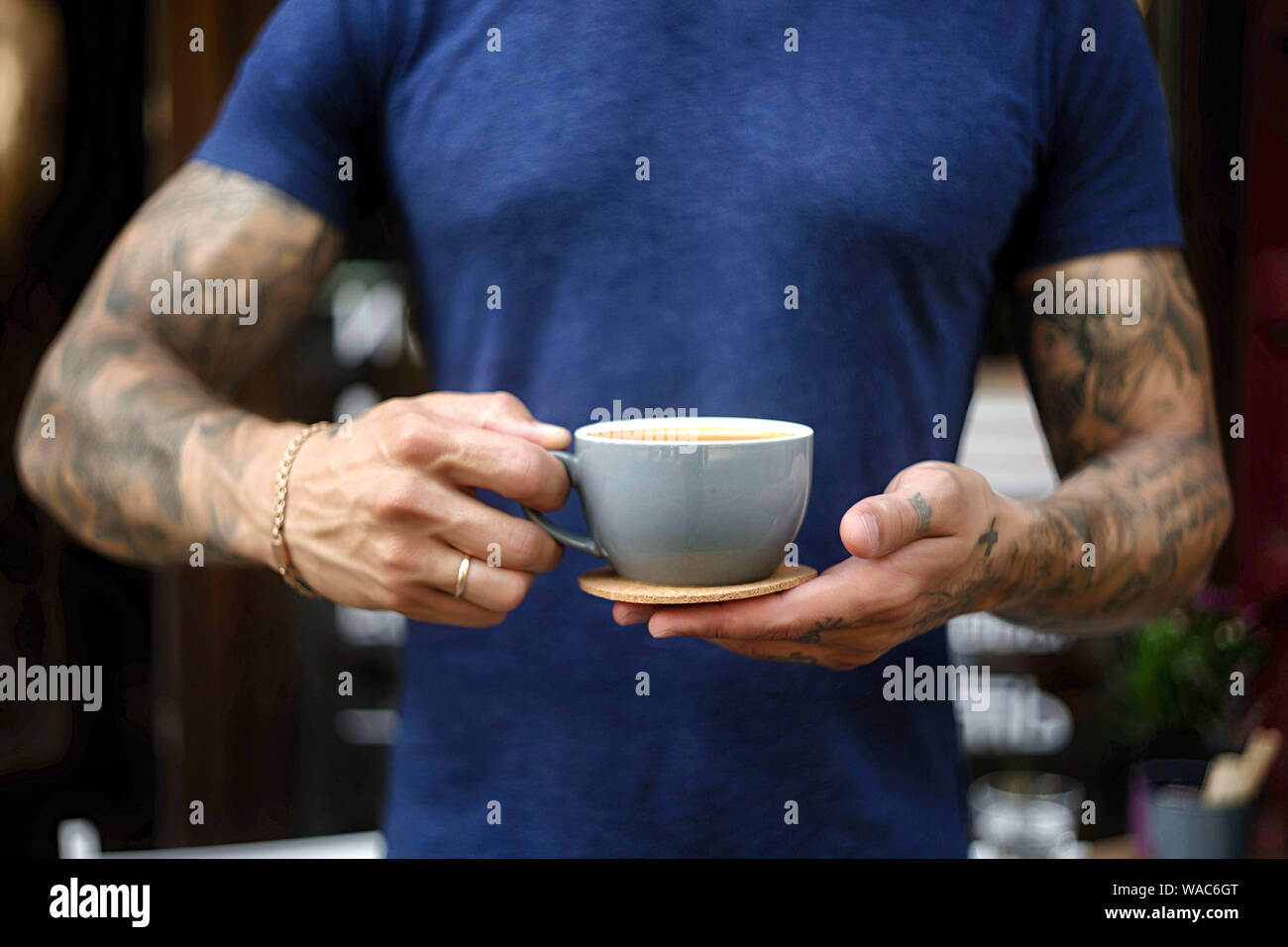 Nahaufnahme des Menschen, die Kaffee im stehen im Café serviert. Fokus auf männliche Hände Inverkehrbringen Zähler eine Tasse Kaffee. Stockfoto