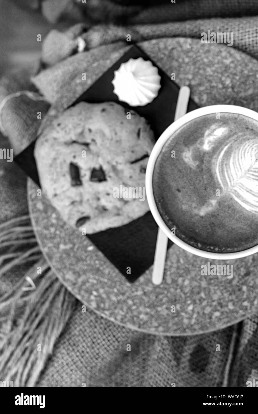 Kaffee mit Milchschaum und Kaffeebohnen in einem Sack auf Beutel Stockfoto