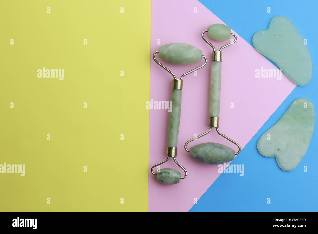 Gesicht und Körper stone Massage Instrumente auf farbigen Hintergrund Stockfoto