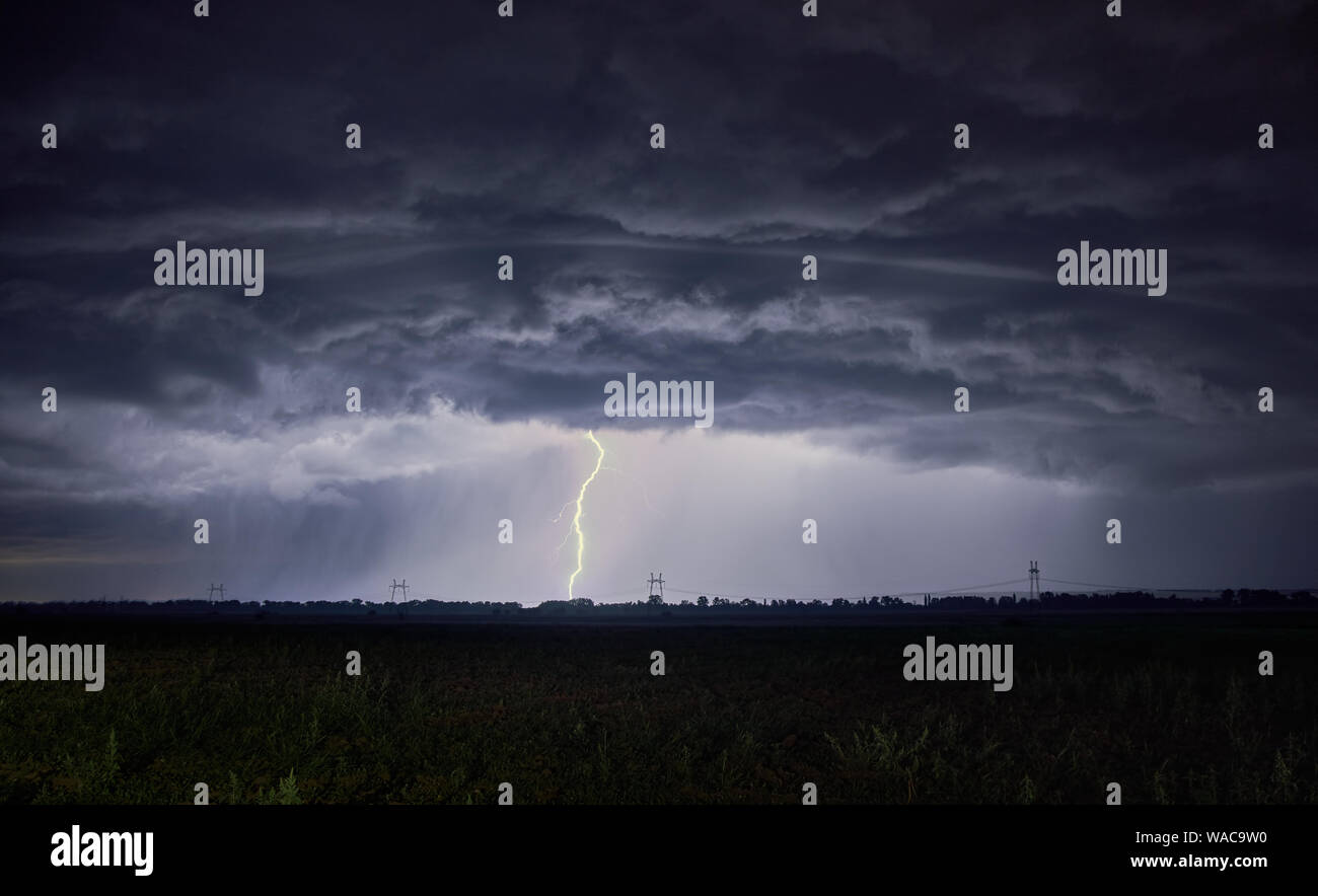 Unrealistisch schöne dicke Wolken und Blitzschlag in den Boden Stockfoto