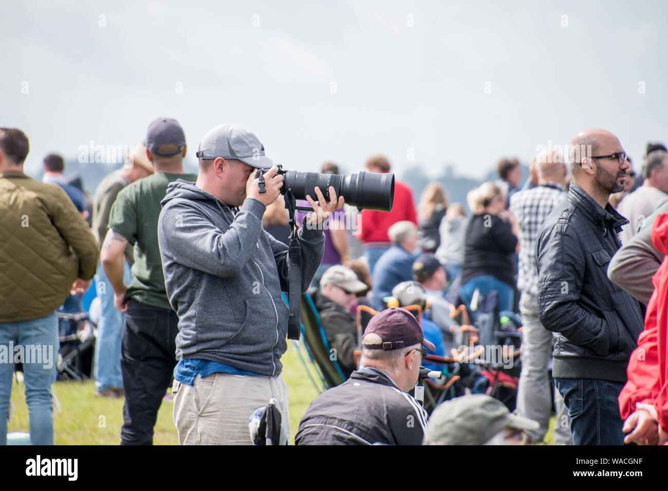 Ein Fotograf mit einem großen Objektiv schießen auf ein Ereignis mit Masse um (REDAKTIONELLE NUR VERWENDEN) Stockfoto