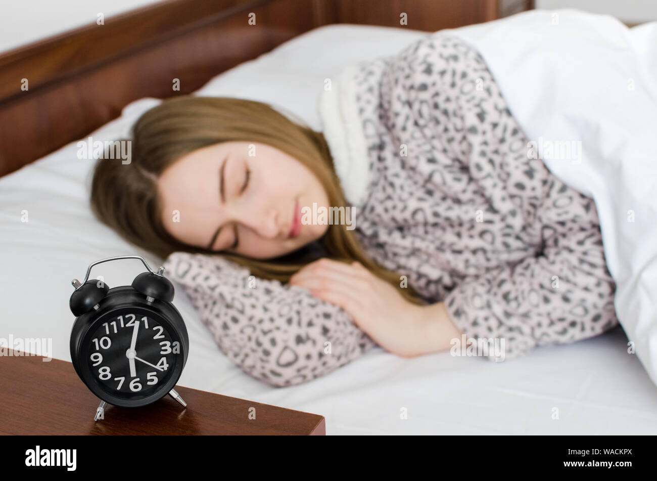 Junge Frau schlafen mit Wecker am Bett am Morgen. Schlafende Mädchen und  Radiowecker im Schlafzimmer zu Hause. Schüler oder Schülerin Angst zu wecken  Stockfotografie - Alamy